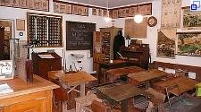 Im Schulmuseum. Ein nachgestelltes altes Schulzimmer mit Reihen von Schülerpulten, dem Lehrerpult und Wandtafeln