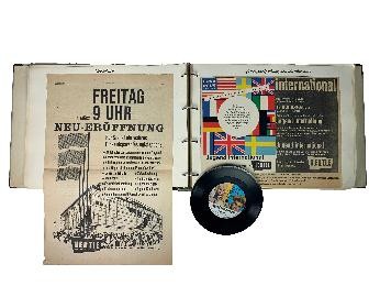 Album mit eingeklebten Zeitungsausschnitten und Schallplatte.