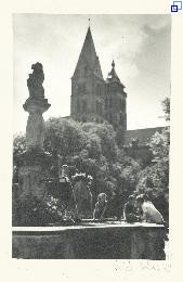 Im Sommer am Marktplatz in Esslingen: Kinder spielen am Becken des Löwenbrunnens. Im Hintergrund Bäume und die Türme der Stadtkirche.
