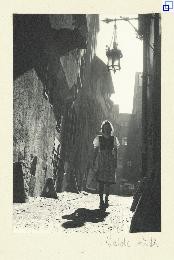 Eine junge Frau in einem Dirndl geht eine Gasse in der Altstadt entlang.