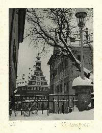 Blick zwischen zwei Hauswänden hindurch, im Hintergrund das Alte Rathaus. Es liegt Schnee.