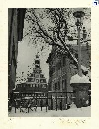Blick zwischen zwei Hauswänden hindurch, im Hintergrund das Alte Rathaus. Es liegt Schnee.