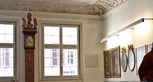 Im Stadtmuseum: Blick ins so genannte Patrizierzimmer mit zwei Fenstern, dazwischen steht eine historische Standuhr. 