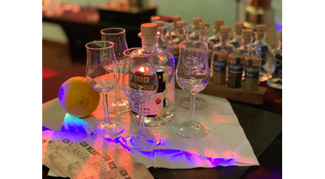 Gläser und Gin-Flasche auf einem Tisch bei stimmungsvoller Beleuchtung: .