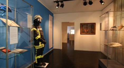 Ausstellungsraum mit Vitrinen und einer Feuerwehruniform.