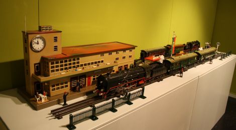 Modelleisenbahnszene: Modell des Bahnhofs Friedrichshafen mit Gleis, Dampfzug und Zubehör.