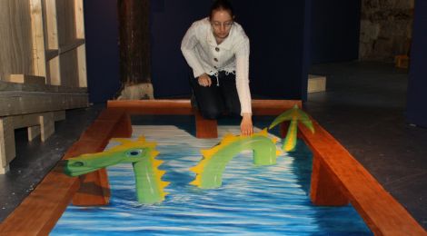 Ausstellungsstück: Ein sehr großes Bild, das flach auf dem Boden liegt, wirkt von einem bestimmten Standpunkt aus dreidimensional. Es erzeugt die Illusion, dass das Ungeheuer von Loch Ness aus einem Wasserbecken herausragt.