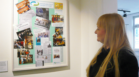 Bei der Eröffnung: Eine Besucherin betrachtet eine Collage mit Fotos und Texten.