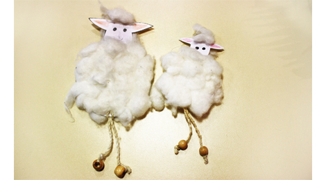 Zwei Schafe mit dem Körper aus gelockter Wolle und dünnen Beinen aus Schnur.
