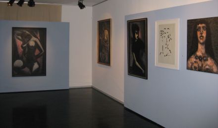 Ausstellungsraum mit mehreren Gemälden. Es sind Porträts von Frauen.