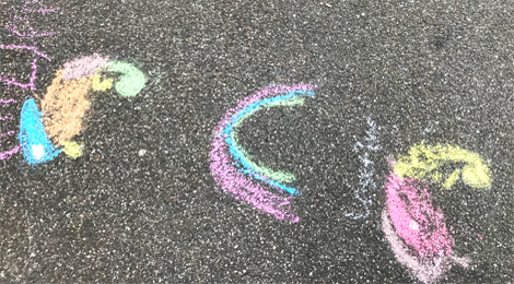 Mit Straßenkreide gemalte Chamäleons und ein Regenbogen.