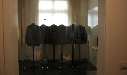 Ausstellungsraum, in dem Uniformjacken aus verschiedenen Zeiten präsentiert werden.