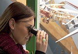 Eine junge Frau betrachtet Kartonmodelle in der großen Vitrine im J. F. Schreiber-Museum im Salemer Pfleghof.