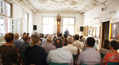 Viele Besucherinnen und Besucher sitzen bei der Eröffnung im Patrizierzimmer.