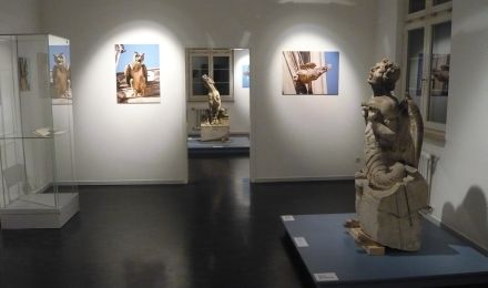 Ausstellungsräume mit Fotografien und zwei ausgestellten Wasserspeiern.