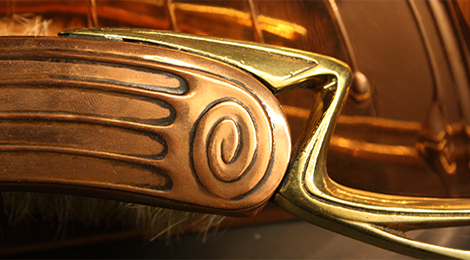 Im sogenannten Silberkabinett: Detailaufnahme des Griffs eines Tischbesens aus Kupfer und Messing, der mit parallelen Streifen und einer Spirale verziert ist