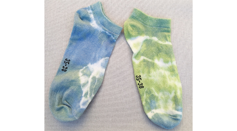 Zwei Socken mit gebatiktem Muster.